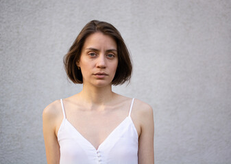 Portrait of a sad serious caucasian woman on a gray background