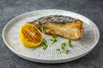 Fillet of white fish grilled or steamed. Diet nutritious meal. Ready menu for the restaurant. Neutral gray blue textured background