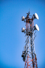 Cellular telecommunication towers against the blue sky. Vertical concept.
