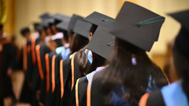 Graduation congratulations,university graduates crowded in the graduation ceremony. The graduates stand in-line while waiting for awarding degree certificate. 