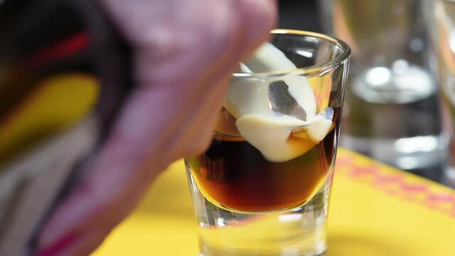 Female Barista Making B-52 Shot With Layering Technique. Irish Cream Poured Slowly Over The Back Of A Cold Spoon Into Coffee Liqueur. close up