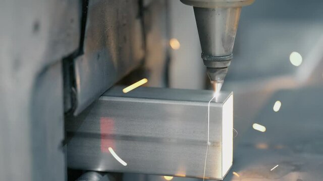 Tube laser cutter is cutting through a stainless steel tube