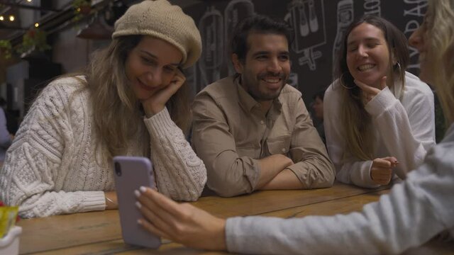 Group facetime a distant lost friend with buddies at the bar