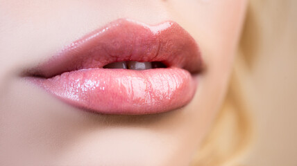 Close-up beautiful lips. Part of face, young woman close up plump lips with nude lipstick. Natural lip lipstick on large lips.