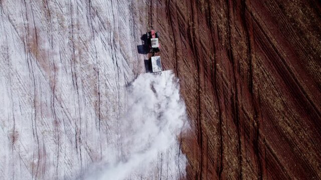 Tractor applying limestone to the soil to correct acidity. 4K.