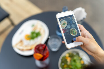 Photographer taking photos of delicious food on smartphone. Food photography concept