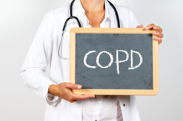 Doctor holds a blackboard with COPD text written on it