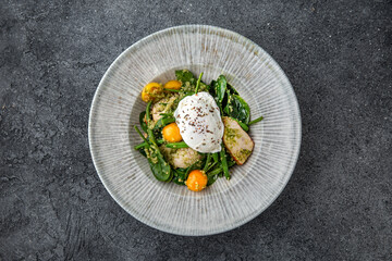 Diet nutritious meal. Green beans with pieces of chicken or turkey fillet with cherry tomatoes and poached egg. Ready menu for the restaurant. Neutral gray blue textured background