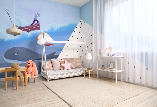 Interior of modern children's room with comfortable bed and beautiful painting on wall