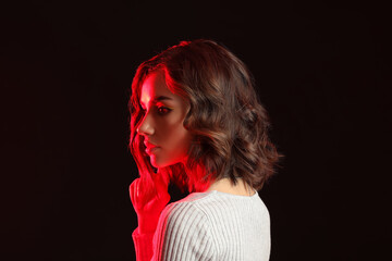 Beautiful young woman on dark background