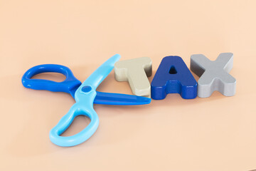 Plastic scissors and three-dimensional English word TAX