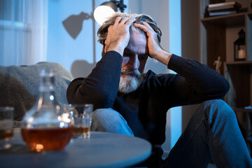 Drunk senior man late in evening at home