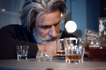 Drunk senior man late in evening at home, closeup