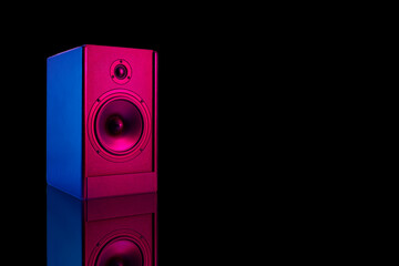 Neon colored stereo speaker on dark background with reflection.Sound audio loud speaker with copy...