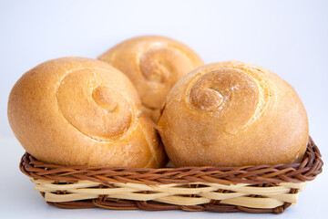 Three freshly baked buns in a wicker plate.Fresh pastries