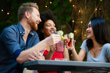 Group of diverse friends talking and having fun at cafe outdoor