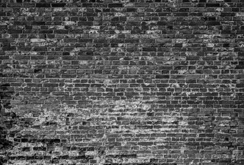 Front view of old and weathered red brick wall. Abstract full frame textured background in black and white.