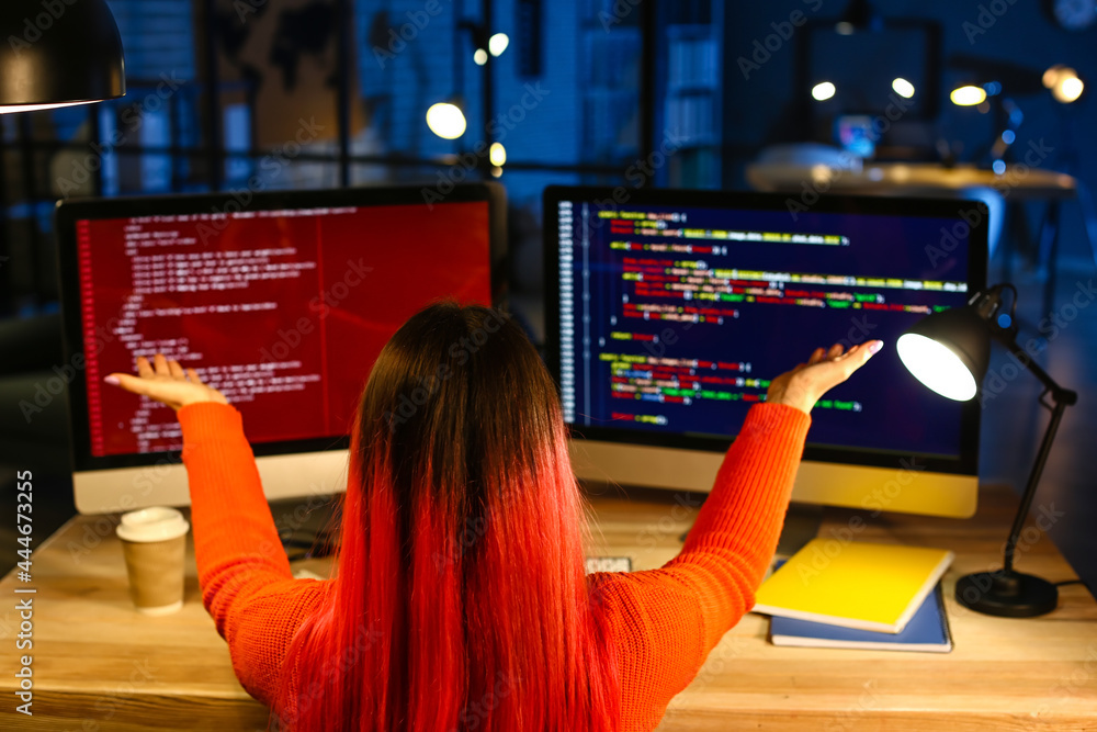 Poster female programmer working with computer in office at night