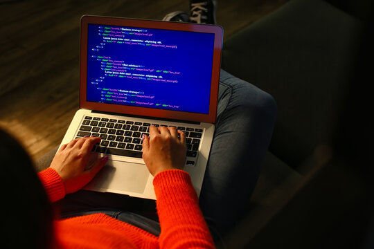 Female programmer working with laptop in office at night