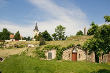 Fototapeta na wymiar Moravian village Vrbice (south Moravian, Morava) with typical brick wine cellars and old historical church in middle of village during sunny summer day without people, Czech republic, Europe