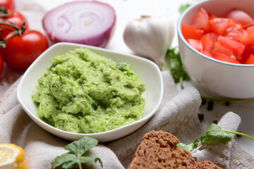 Bowl with tasty guacamole on table, closeup