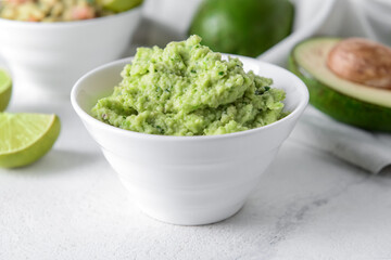 Bowl with tasty guacamole on table, closeup