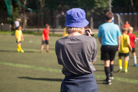 The girl is watching football. The woman is watching the match.