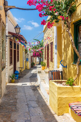 Traditional cycladitic   alley with narrow street, traditional houses and a blooming bougainvillea, in ano Syros Greece