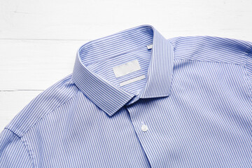 Stylish male shirt on light wooden background