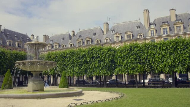 One Of The Fountains At Square Louis XIII In Place des Voges, Paris, France With Houses In Background. wide shot, slider left