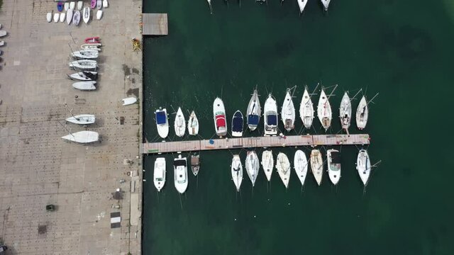 small boats are moored to the seashore. Drone view