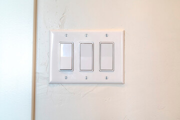 Rocker light switch with multiple flat broad lever mounted on the interior wall