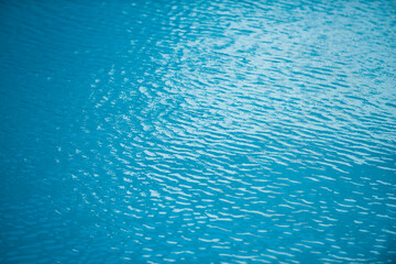 Abstract ripple wave and clear turquoise water surface in swimming pool, blue water wave for background and abstract design.