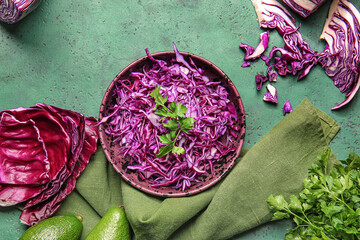 Bowl with cut fresh purple cabbage and parsley on color background