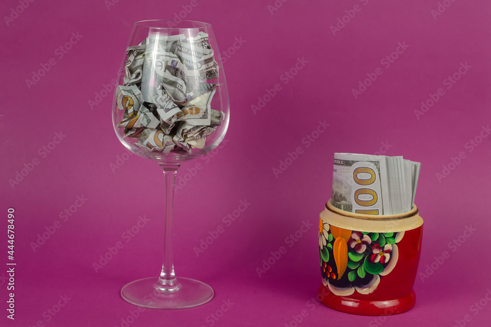 Wall mural Composition with a wine glass, matreshka and money on a pink bac