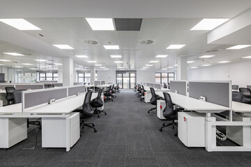 Modern corporate open office in minimalist modern design in whites and greys, empty office workstations. - obrazy, fototapety, plakaty
