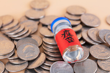 A bottle of vaccine medicine on a pile of coins
