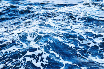 deep blue sea surface with wave by the heavy wind with many white bubble