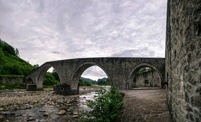 Fototapeta na wymiar Ancient stone Turkish bridge and mountain river