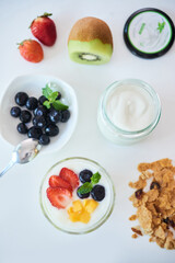 Table with jar of yogurt, muesli and berries with fruits for breakfast