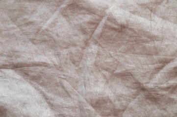 The texture of a crumpled sand-colored fabric