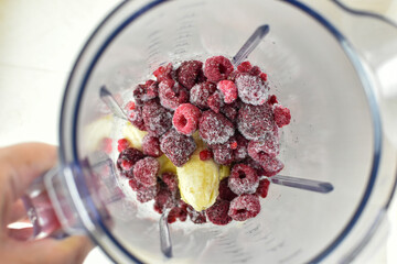 frozen raspberries in blender jug for smoothie making 