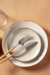 Modern ceramic plates with cutlery, shot from above with a place for text. Trendy dinner setting