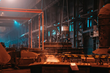 Foundry workshop. Metallurgical plant with unrecognizable workers. Heavy industry background.