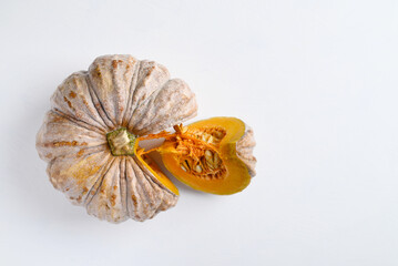 Close up of cutting organic pumpkin on white background