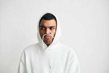 Minimal portrait of young man wearing hoodie and making faces, copy space