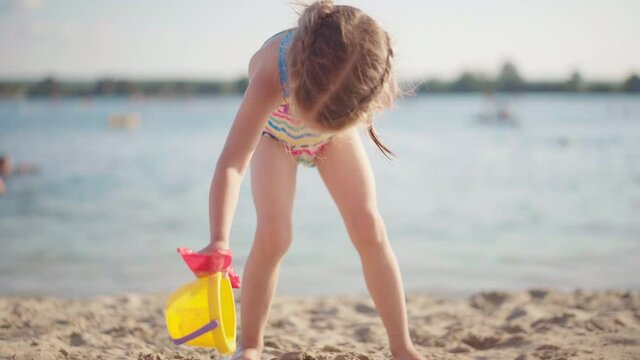 Little Girl Playing Beach With Plastic Toys Dressed Swimwear Summer Day. High quality 4k footage