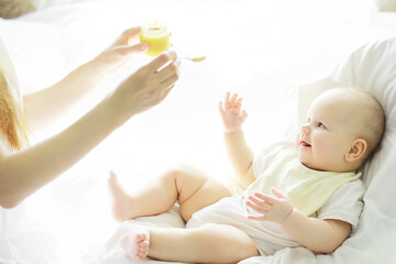 Maternity concept. A young mother feeds her little baby. First lure and breastfeeding. Family in...