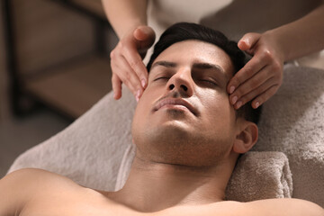 Fototapeta na wymiar Man receiving facial massage in beauty salon