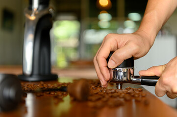 The barista preparing various tools to make espresso.